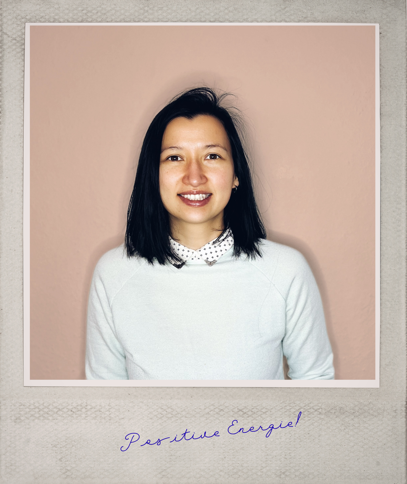 Foto einer offen lächhelnden jungen Frau mit dunklem glatten Haar bis zur Schulter in einem weißen Pullover mit Hemdkragen vor einem apricot-farbenen Hintergrund